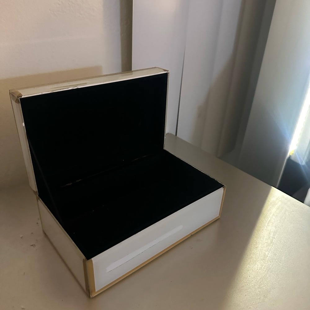 White jewelry box with gold trim.